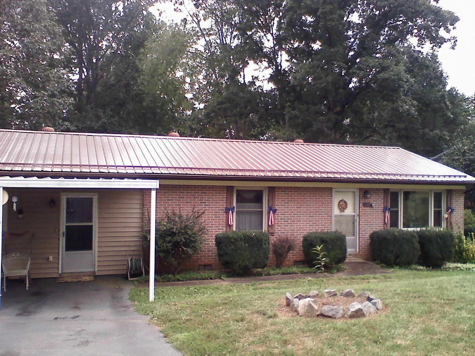 Bronze metal roof and carport on a brick ranch home — Roof Repair work by our crew in Jensen Beach
