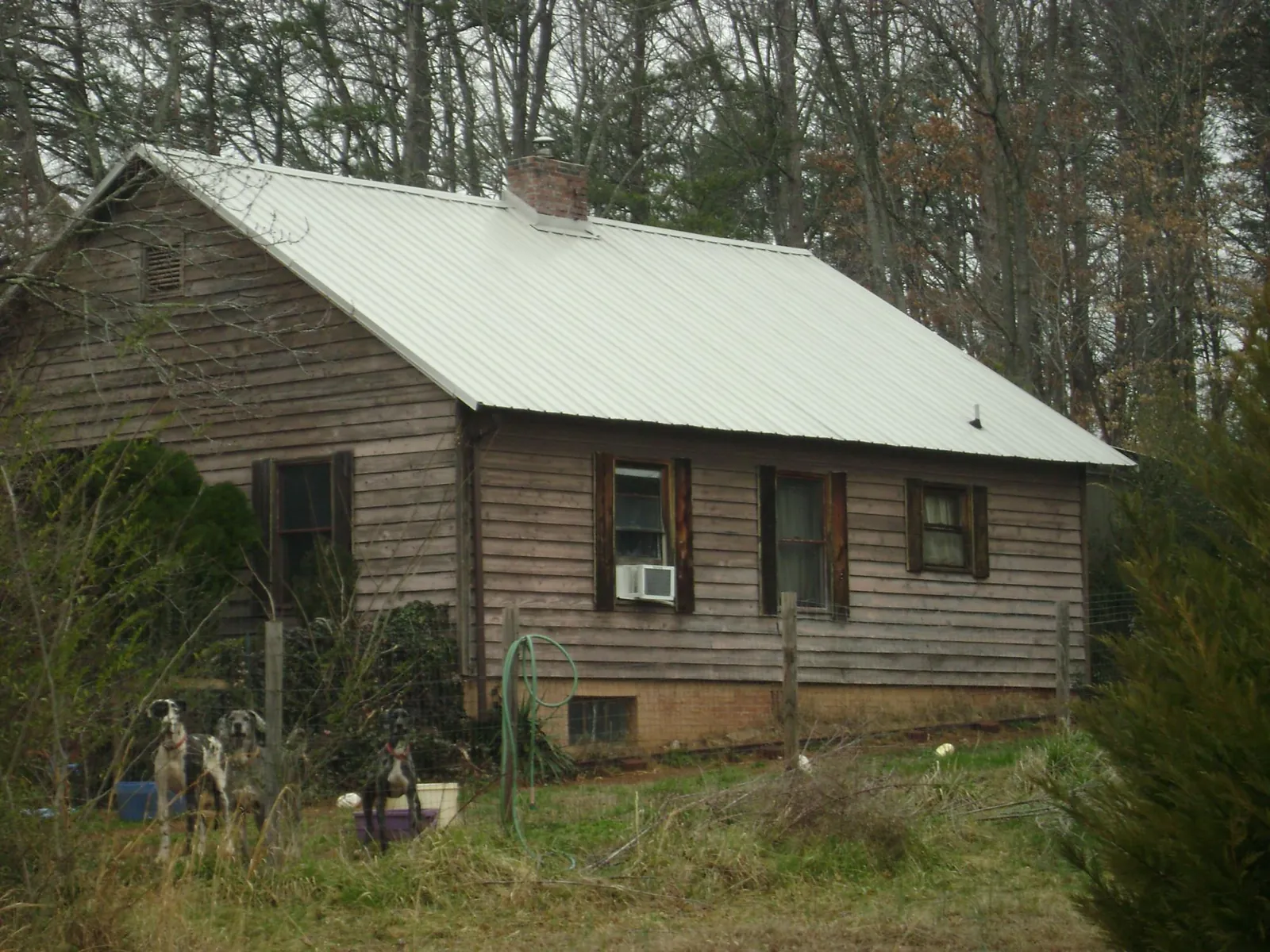 White metal roof on an old wood sided farmhouse, from a Metal Roof Installation job in Jensen Beach